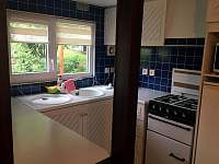kuchyňský kout s lednicí, sporákem a mikrovlnkou - pohled z obývací části - chata ubytování Malé Žernoseky