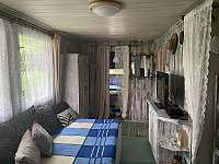 Obývák s rozloženou sedačkou…vzadu ložnice s manželskou postelí… - chata k pronajmutí Všemily