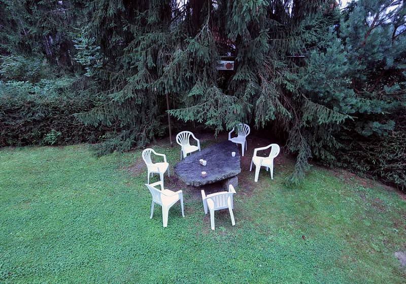 Kamenný stůl v dolní úrovni pozemku pod vzrostlým smrkem