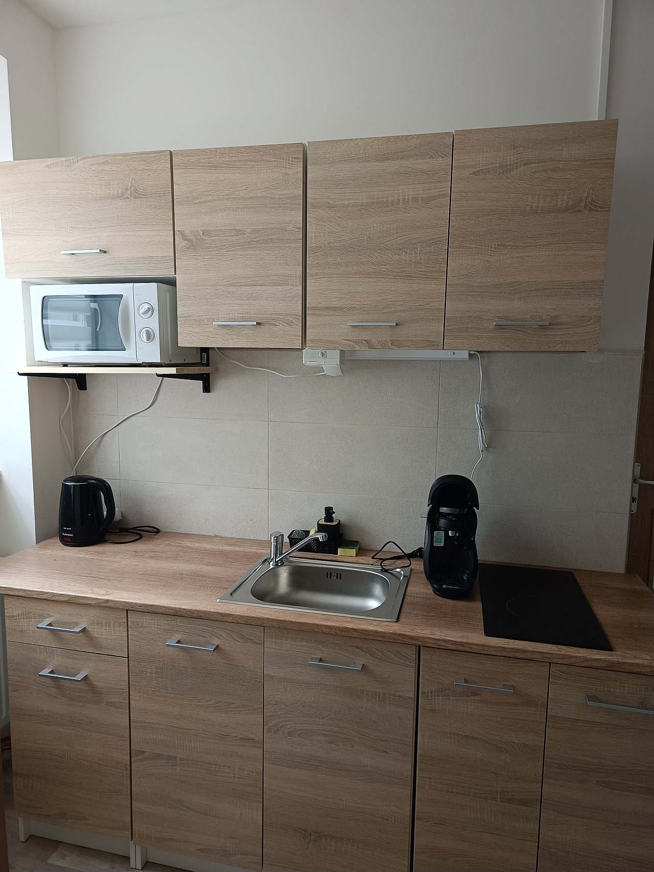 Kuchyň s varnou deskou a kávovarem