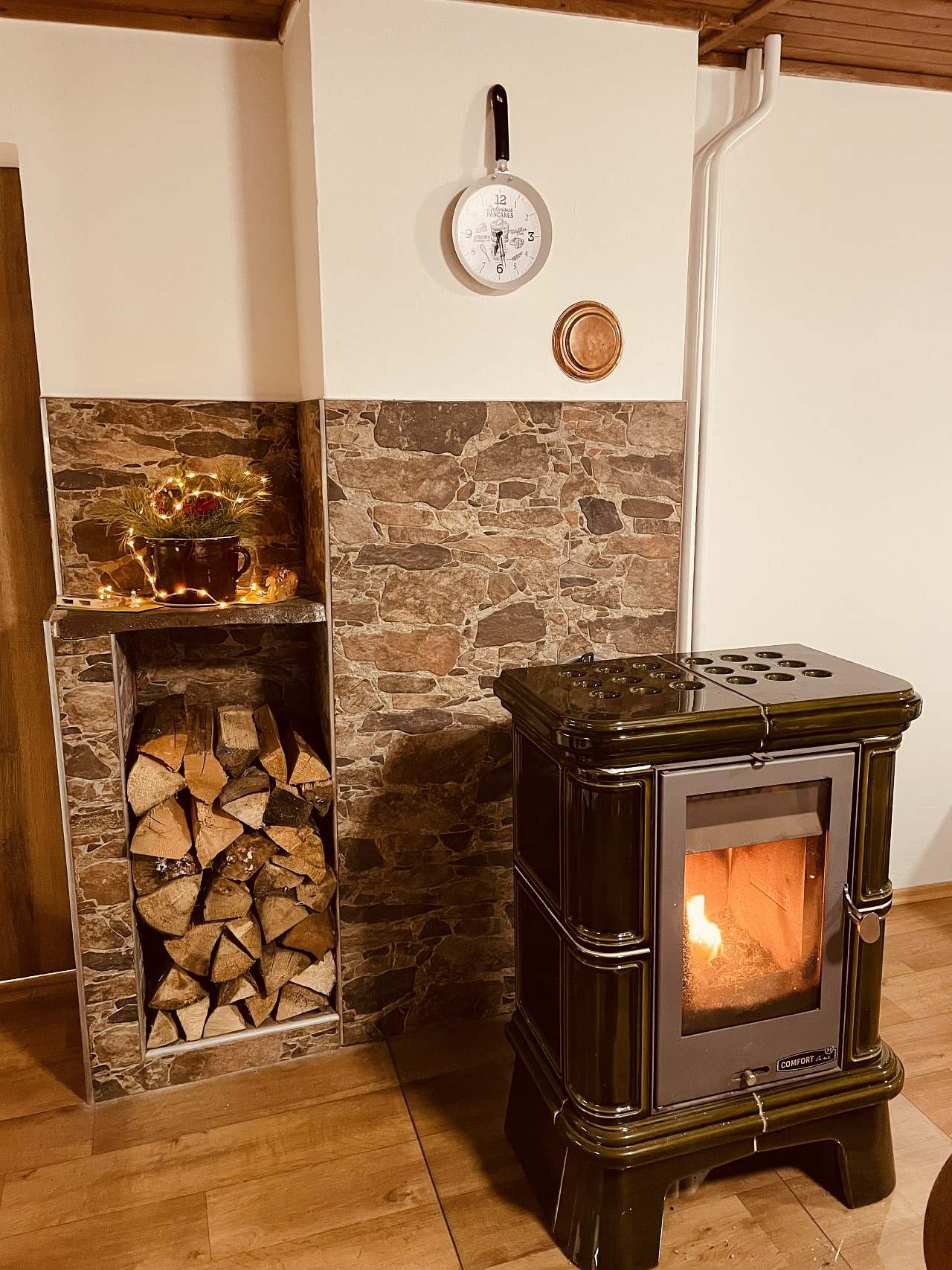 Obývací pokoj s jídelnou, kuchyní a vnitřním krbem.