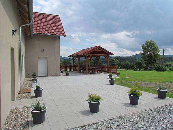 Prostorná terasa s pergolou a venkovním posezením