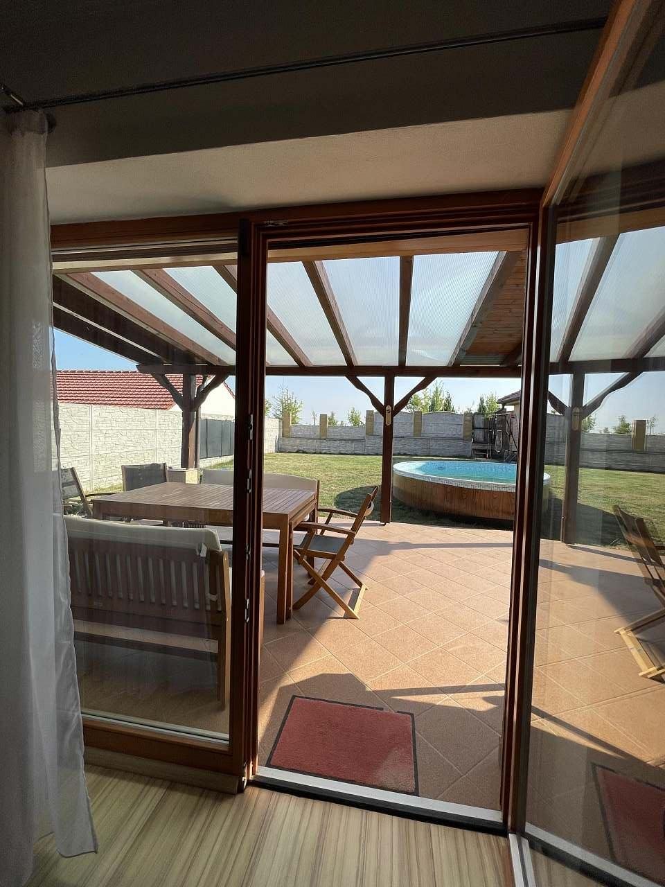 Průhled z obývacího pokoje přes tersau na dvůr