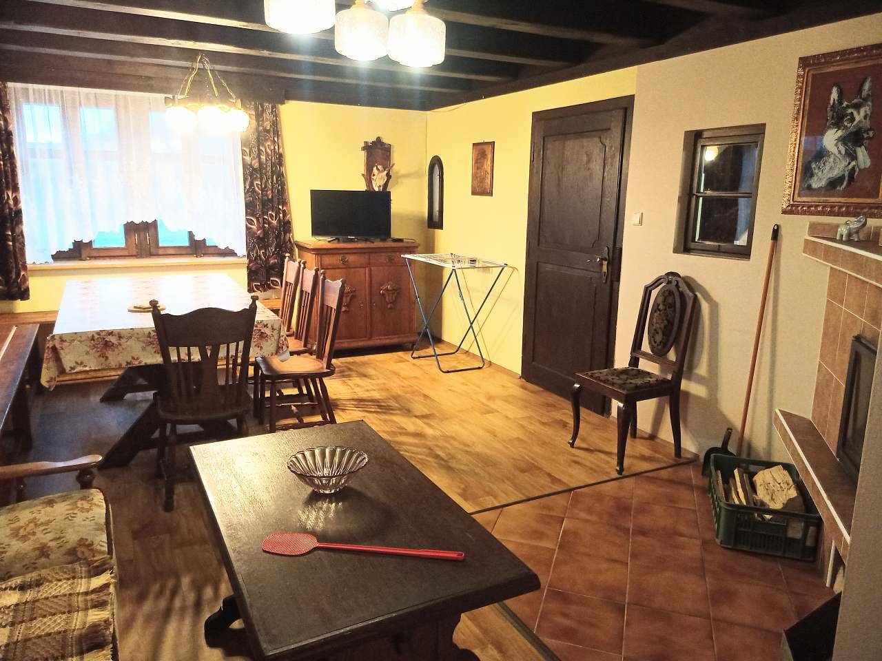 Společenská místnost s krbem, pohovkou a TV.