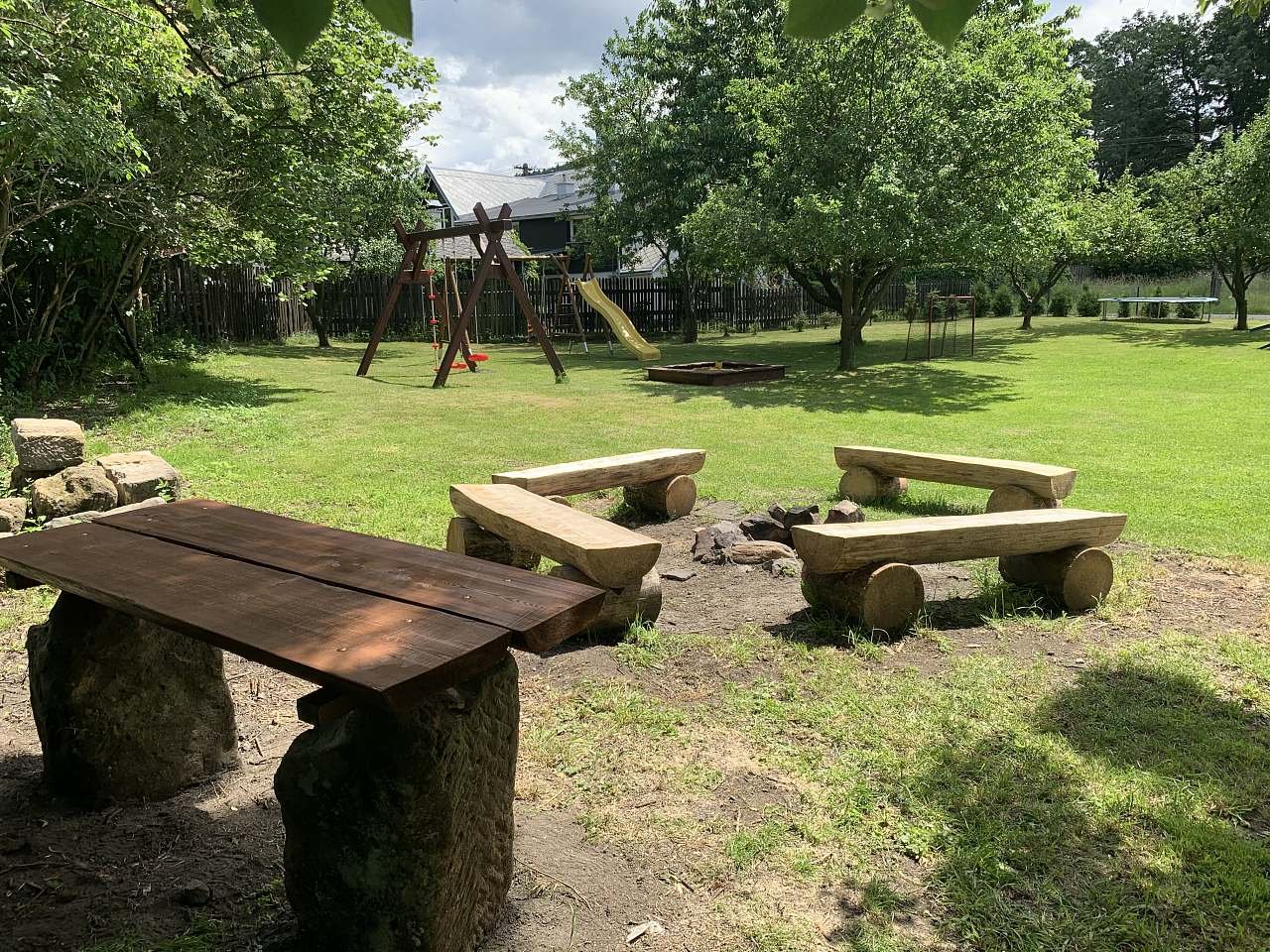 Zahrada - pohled na houpačky s ohništěm