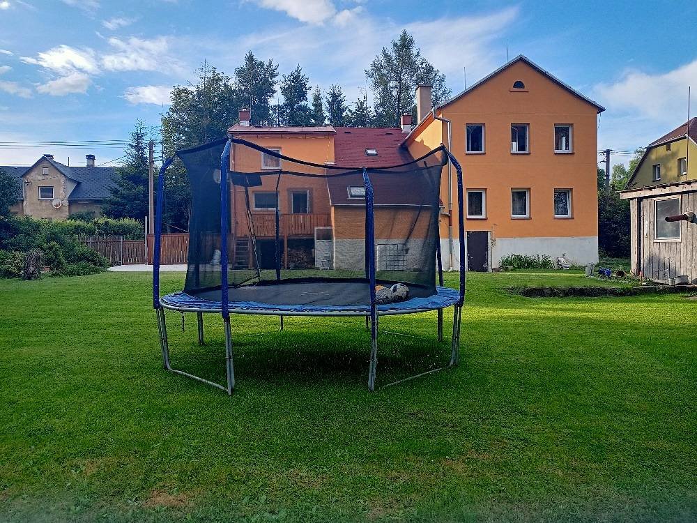 Zahrada s trampolínou a posezením