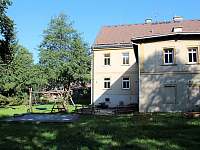 Pohled na posezení, houpačky, podium a vyvýšené záhony na zahradě - Oldřichov v Hájích