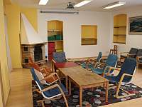 Společenská místnost s krbem, dataprojektorem a s promítacím plátnem - chalupa ubytování Oldřichov v Hájích