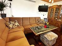 Obývací pokoj s rozkládací sedačkou, TV a stolem - chata k pronájmu Vlčnov
