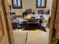 Obývací pokoj s kachlovými kamny - pronájem roubenky Tupadly