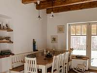 Kuchyň s jídelním koutem, obývací částí a kachlovými kamny.