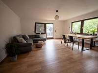 Obývací pokoj s dřevěným nábytkem a rozkládací sedací soupravou