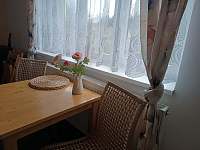 Obývací pokoj s rozkládací pohovkou, stolem a kuchyňským koutem. - pronájem apartmánu Teplice nad Metují